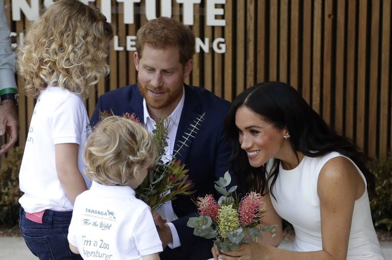 The Duke and Duchess of Sussex receive native flowers from Finley Blue and Dasha Gallagher, left, at Taronga Zoo in Sydney, Australia. The Duke and Duchess of Sussex receive native flowers from Finley Blue and Dasha Gallagher, left, at Taronga Zoo in Sydney, Australia.