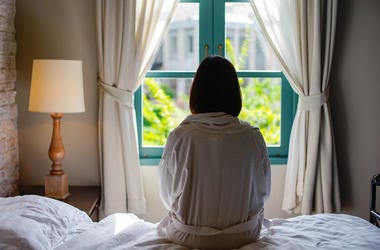 Woman Sitting On A Bed