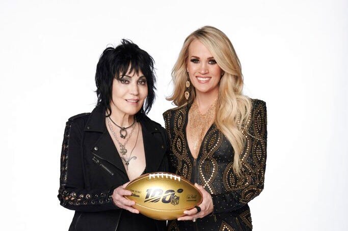 Joan Jett, left, and Carrie Underwood pose with a 100th anniversary NFL football. Joan Jett, left, and Carrie Underwood pose with a 100th anniversary NFL football.