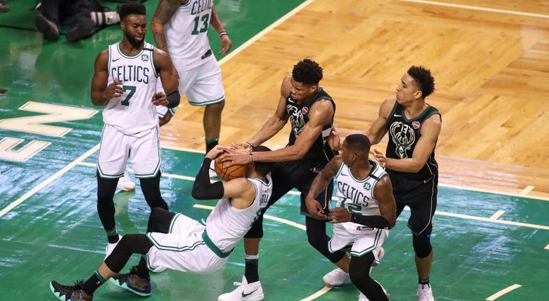 Jayson Tatum battles Giannis Antetokounmpo for the ball