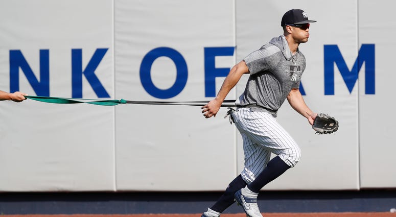 New York Yankees' Giancarlo Stanton, who has been out the much of the season with various injuries, trains with a resistance band in the outfield before a baseball game between the Yankees and the Texas Rangers, Wednesday, Sept. 4, 2019, in New York New York Yankees' Giancarlo Stanton, who has been out the much of the season with various injuries, trains with a resistance band in the outfield before a baseball game between the Yankees and the Texas Rangers, Wednesday, Sept. 4, 2019, in New York