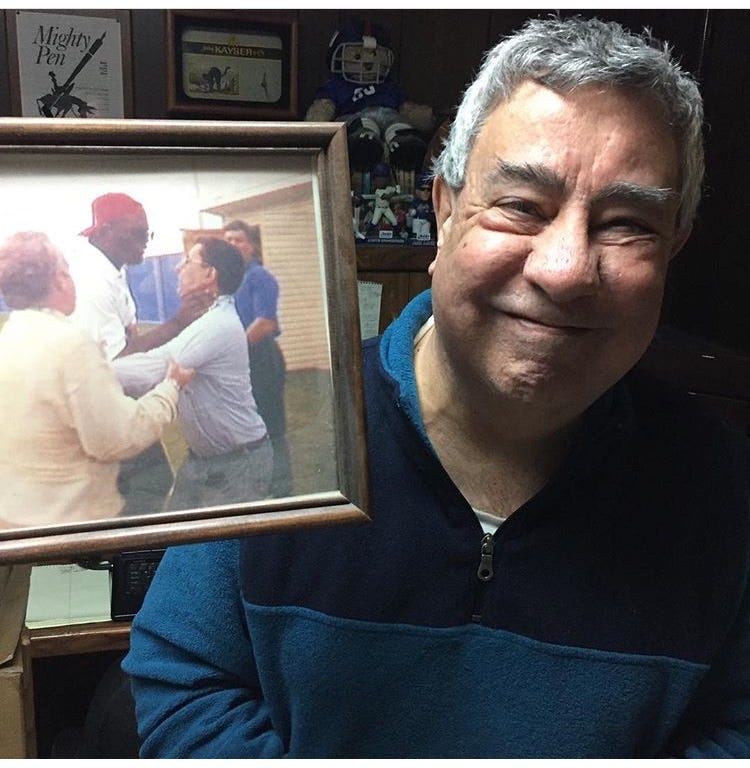 Ernie Palladino poses with a photo of Lawrence Taylor choking him. Ernie Palladino poses with a photo of Lawrence Taylor choking him.