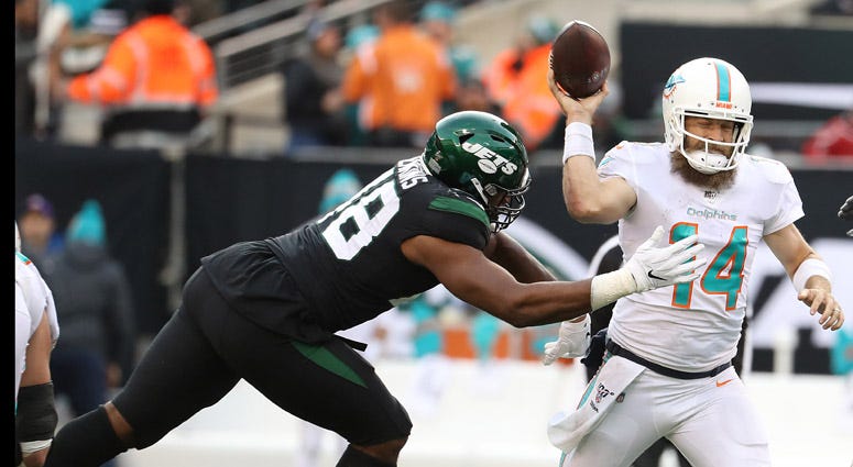 Dolphins quarterback Ryan Fitzpatrick passes as he is pressured by Jets linebacker Jordan Jenkins on Dec. 8, 2019, at MetLife Stadium. Dolphins quarterback Ryan Fitzpatrick passes as he is pressured by Jets linebacker Jordan Jenkins on Dec. 8, 2019, at MetLife Stadium.