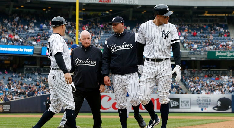 The Yankees' Aaron Judge is checked on by bench coach Josh Bard, trainer Steve Donohue and first-base coach Reggie Willits prior to leaving a game against the Kansas City Royals in the sixth inning at Yankee Stadium on April 20, 2019. The Yankees' Aaron Judge is checked on by bench coach Josh Bard, trainer Steve Donohue and first-base coach Reggie Willits prior to leaving a game against the Kansas City Royals in the sixth inning at Yankee Stadium on April 20, 2019.