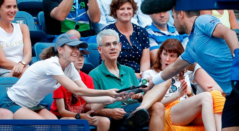 Stan Wawrinka hands his broken racquet to a fan. (USA TODAY Images)