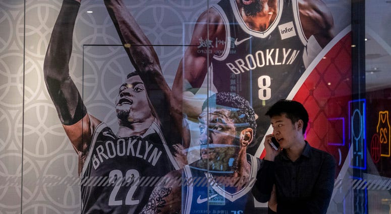 A Chinese man talks on his phone next to a billboard showing players from the Brooklyn Nets outside the NBA flagship retail store on Oct. 9, 2019 in Beijing. A Chinese man talks on his phone next to a billboard showing players from the Brooklyn Nets outside the NBA flagship retail store on Oct. 9, 2019 in Beijing.