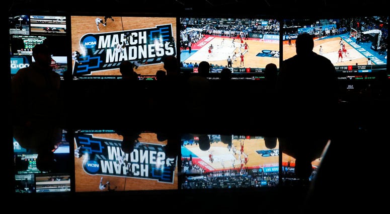 In this March 15, 2018 photo, people watch coverage of the first round of the NCAA college basketball tournament at the Westgate Superbook sports book in Las Vegas. In this March 15, 2018 photo, people watch coverage of the first round of the NCAA college basketball tournament at the Westgate Superbook sports book in Las Vegas.