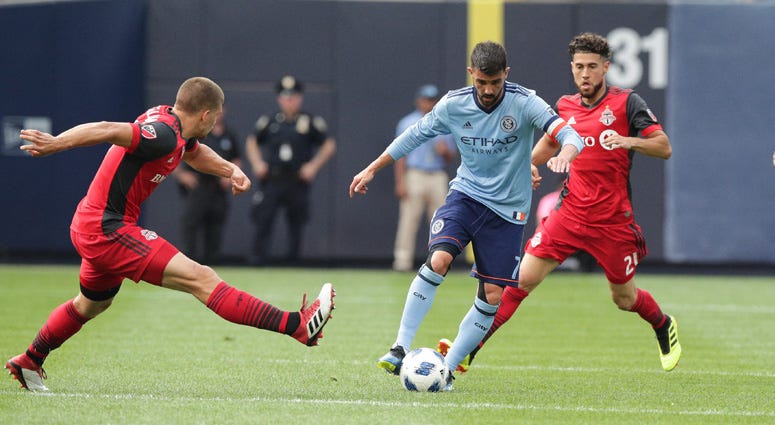 New York City forward David Villa controls the ball as Toronto FC midfielder Jonathan Osorio (21) and defender Nick Hagglund on Aug. 12, 2018, at Yankee Stadium. New York City forward David Villa controls the ball as Toronto FC midfielder Jonathan Osorio (21) and defender Nick Hagglund on Aug. 12, 2018, at Yankee Stadium.