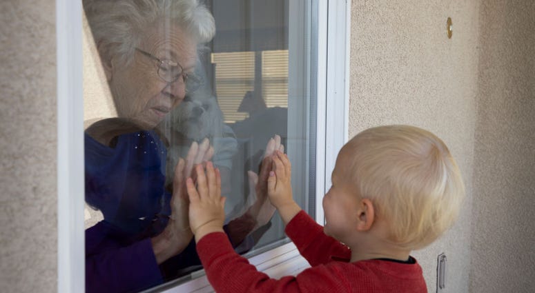 Mary-Lou McCullagh, 83, and her husband Bob, 84, greet Axel Stirton, 2, the little boy who lives across the street April 3, 2020 in Ventura, California. Mary-Lou McCullagh, 83, and her husband Bob, 84, greet Axel Stirton, 2, the little boy who lives across the street April 3, 2020 in Ventura, California.