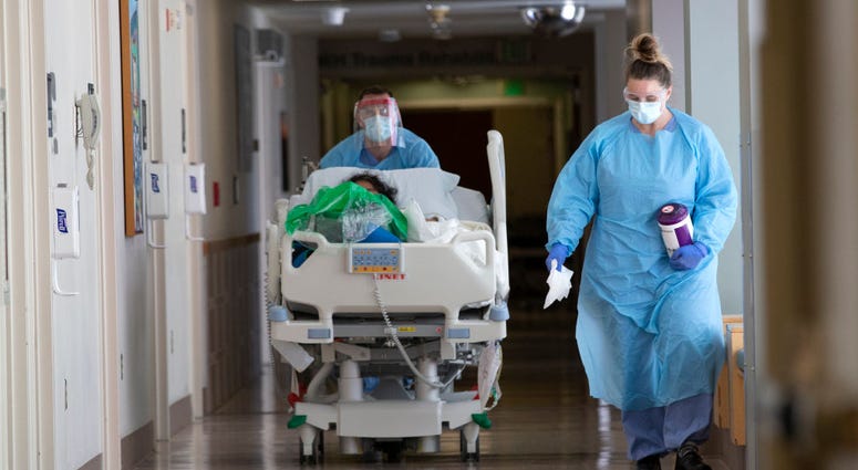 A nurse on infection control accompanies a patient being transferred from the ICU COVID unit to the acute care COVID unit at Harborview Medical Center on May 7, 2020 in Seattle, Washington. A nurse on infection control accompanies a patient being transferred from the ICU COVID unit to the acute care COVID unit at Harborview Medical Center on May 7, 2020 in Seattle, Washington.