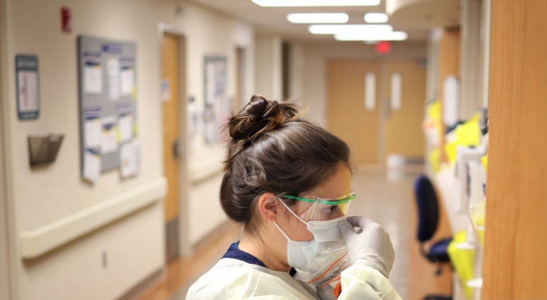 ) Nurses in the COVID-19 unit of MedStar St. Mary's Hospital check the fit of protective equipment before entering a patient's room March 24, 2020 in Leonardtown, Maryland