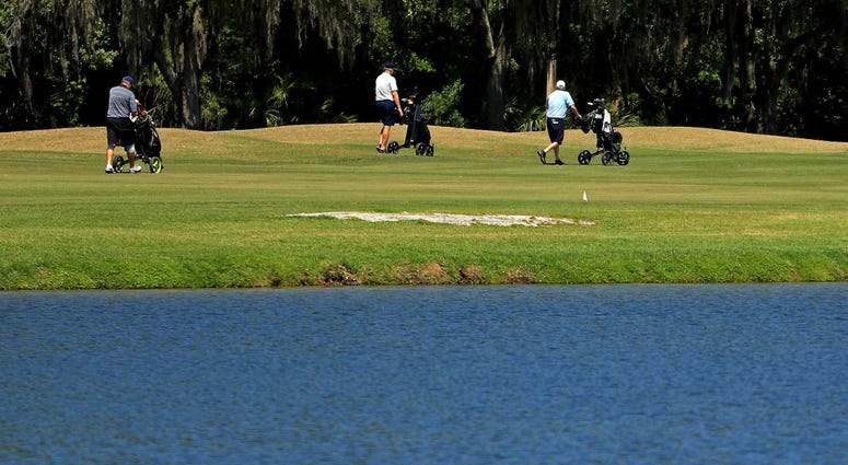 As golf courses change their protocols in response to the coronavirus pandemic, some golfers choose to walk at Westchase Golf Club on March 28, 2020 in Tampa, Florida
