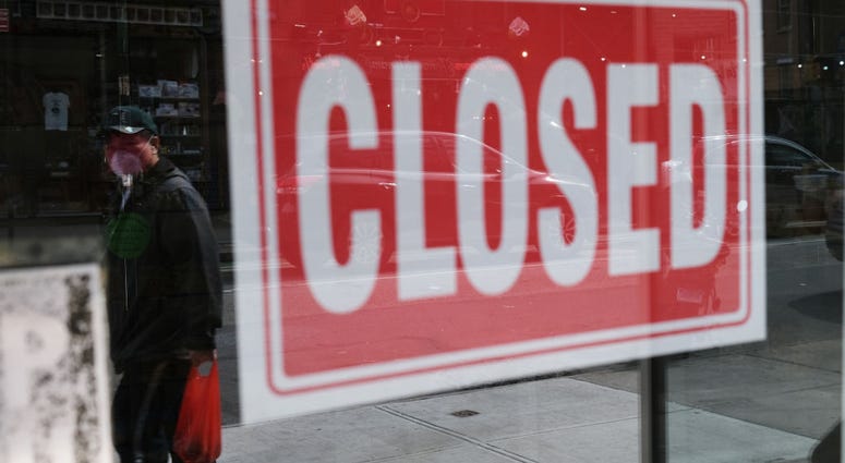 Photo by Spencer Platt/Getty Images) A store stands closed as the coronavirus keeps financial markets and businesses mostly closed on April 21, 2020 in New York City.