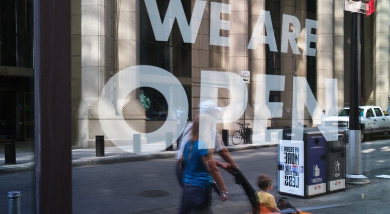 People walk in front of a recently opened business as Manhattan enters Phase 2 of re-opening following restrictions imposed to curb the coronavirus pandemic on June 22, 2020 in New York City.