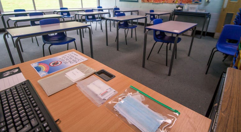 Spare face masks are seen on a teachers desk as a classroom is set out for social distancing at Longdendale High School on July 16, 2020 in Hyde, England