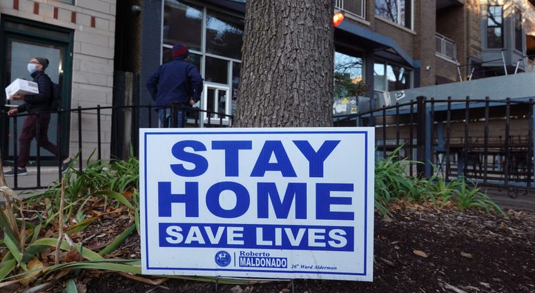 A sign along the sidewalk in an area lined with bars and restaurants in the Wicker Park neighborhood encourages people to stay home on November 11, 2020 in Chicago, Illinois.