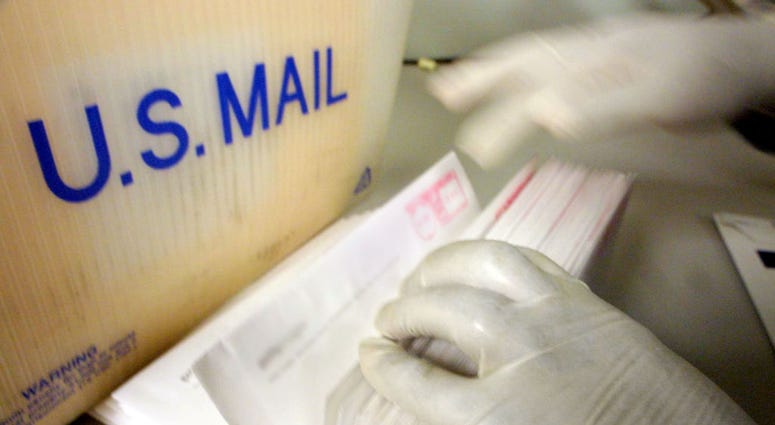 A corporate mailroom employee uses gloves while sifting through letters October 15, 2001 in New York City.