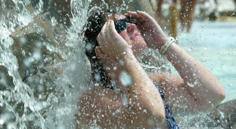 Janet Kelly from Huntingtown Maryland cools off under a waterfall at the Chesapeake Beach Water Park August 16, 2002 in Chesapeake Beach, Maryland