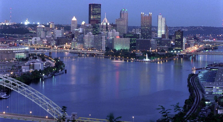 View of the downtown Pittsburgh skyline at dusk, showing the Allegheny and Monongahela rivers joining to form the Ohio River.