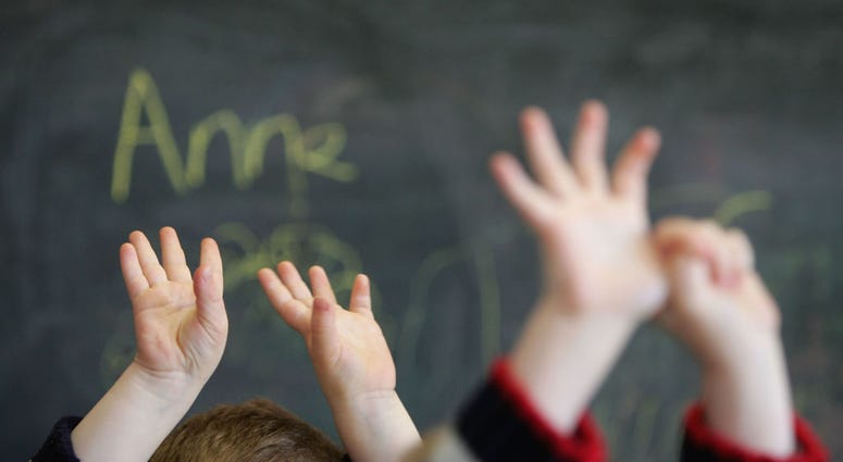 Children wave their hands at a private nursery school January 28, 2005 in Glasgow, Scotland.
