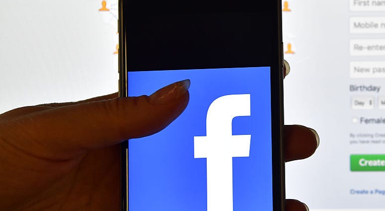 LONDON, ENGLAND - AUGUST 03: A person holds an iPhone displaying the Facebook app logo in front of a computer screen showing the facebook login page on August 3, 2016 in London, England. LONDON, ENGLAND - AUGUST 03: A person holds an iPhone displaying the Facebook app logo in front of a computer screen showing the facebook login page on August 3, 2016 in London, England.
