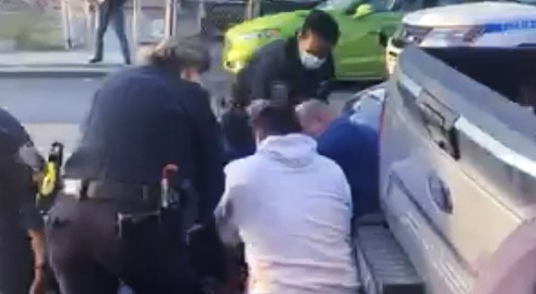In this April 29, 2020 image made from video provided by Adegoke Atunbi, New York City police officers wrestle a man to the ground while making an arrest in the Brooklyn borough of New York. NYPD social distancing