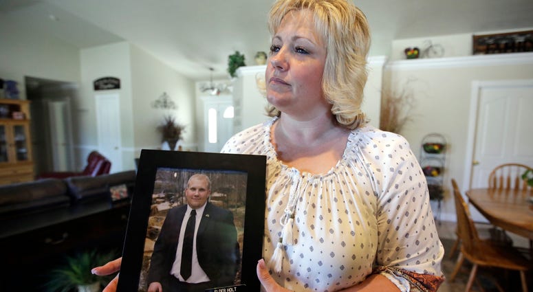 FILE - In this July 13, 2016 file photo, Laurie Holt holds a photograph of her son Josh Holt at her home, in Riverton, Utah. FILE - In this July 13, 2016 file photo, Laurie Holt holds a photograph of her son Josh Holt at her home, in Riverton, Utah.