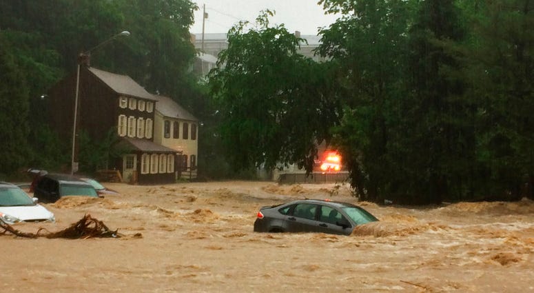 Water rushes through Main Street in Ellicott City, Md.