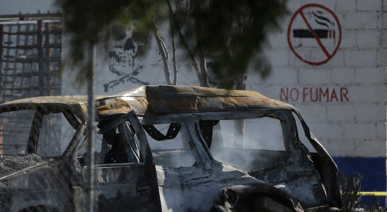 A soldier guards the perimeter around the wreckage of several fireworks workshops in Tultepec, Mexico, Thursday, July 5, 2018. A soldier guards the perimeter around the wreckage of several fireworks workshops in Tultepec, Mexico, Thursday, July 5, 2018.