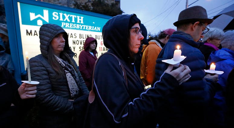 crowd holds candles on the lawn of the Sixth Presbyterian Church at the intersection of Murray Ave. and Forbes Ave. in the Squirrel Hill section of Pittsburgh during a memorial vigil for the victims of the shooting at the Tree of Life Synagogue. synagogue shooting memorial