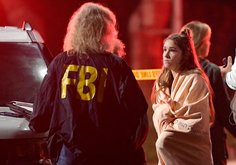 An FBI agent talks to a potential witness as they stand near the scene Thursday, Nov. 8, 2018, in Thousand Oaks, Calif. where a gunman opened fire. An FBI agent talks to a potential witness as they stand near the scene Thursday, Nov. 8, 2018, in Thousand Oaks, Calif. where a gunman opened fire.