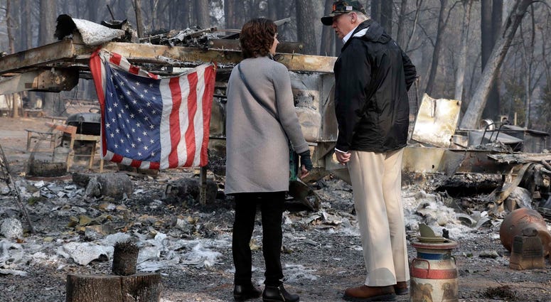 President Donald Trump talks to Mayor Jody Jones as he visits a neighborhood impacted by the wildfires, Saturday, Nov. 17, 2018, in Paradise, Calif. California Wildfires