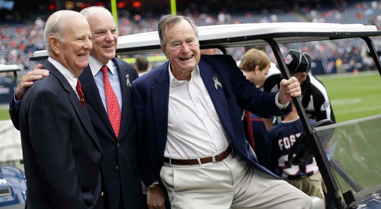 In this Nov. 4, 2012 file photo, former President George H. W. Bush, right, former Secretary of State James Baker, left, and Houston Texans owner Bob McNair pose together before an NFL football game against the Buffalo Bills in Houston. George H.W. Bush