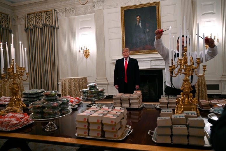 President Donald Trump talks to the press about the table full of fast food in the State Dining Room of the White House in Washington, Monday, Jan. 14, 2019, for the reception for the Clemson Tigers. Trump McDonalds