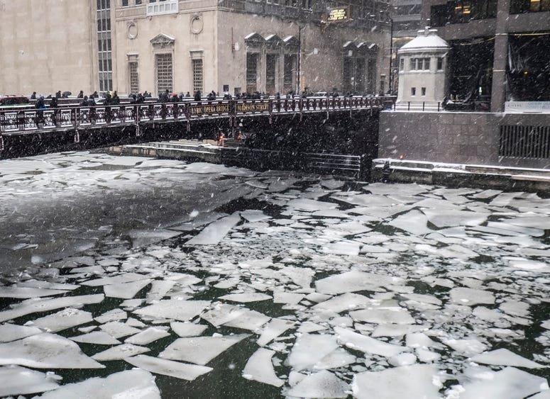Pedestrians cross an icy Chicago River on Madison St. near the Civic Opera House in Chicago, Monday, Jan. 28, 2019. Chicago snow