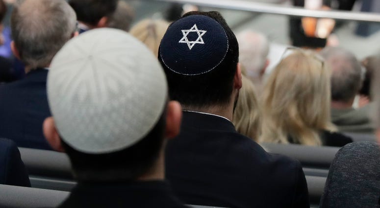 Two men wearing skullcaps as they listen to the speech of Israeli Historian Saul Friedlaender. Skullcap