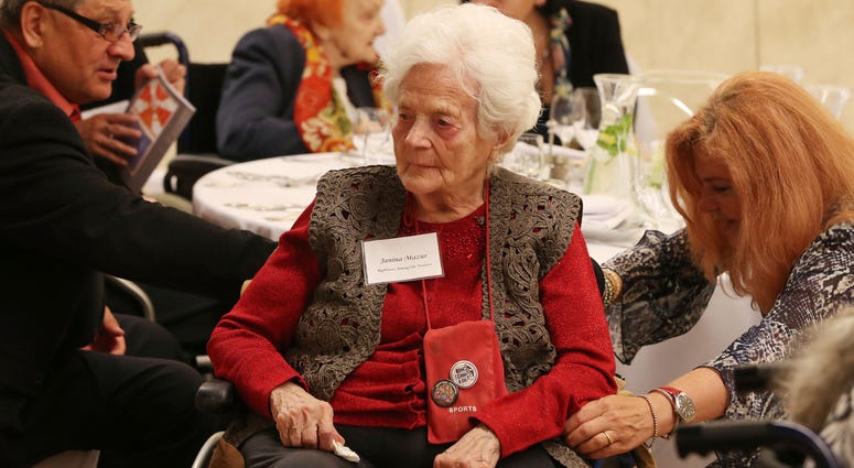 Janine Mazur, center, listens to speeches during an event to honor Polish people who saved Jews during WWII, in Warsaw, Poland, Sunday, Sept. 8, 2019. Poland