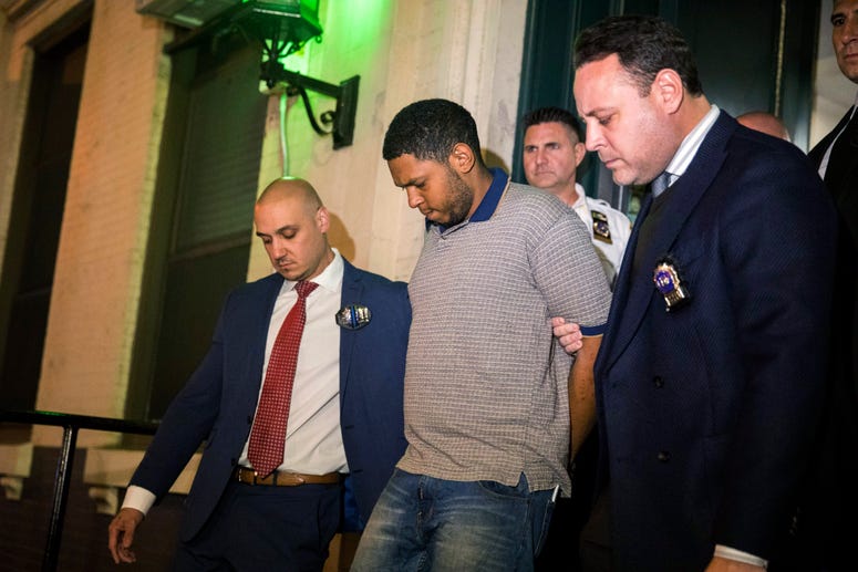 Police officers escort Randy Rodriguez Santos from the 5th Precinct to a vehicle bound for a hospital for evidence collection, Saturday, Oct. 5, 2019, in New York. Randy Rodriguez Santos Chinatown