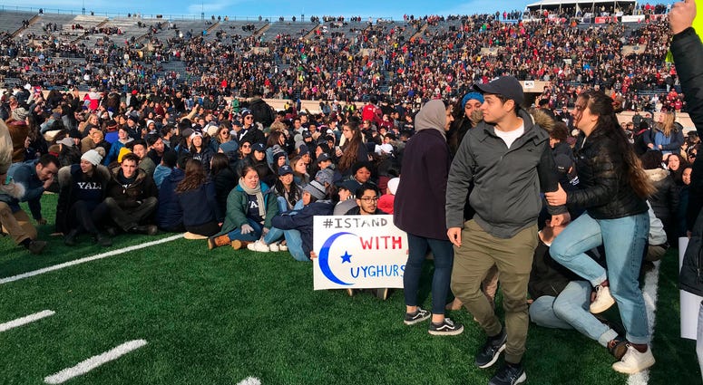 Demonstrators stage a protest on the field at the Yale Bowl disrupting the start of the second half of an NCAA college football game between Harvard and Yale, Saturday, Nov. 23, 2019, in in New Haven, Conn. Climate protest Yale Harvard game