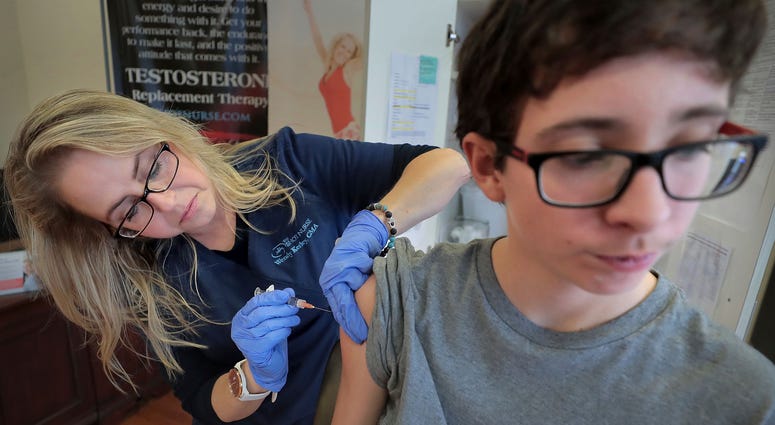 In this Jan. 3, 2019, file photo, Wendy Kerley gives Ethan Getman, 15, a shot of the flu vaccine at the Cordova Shot Nurse clinic in Memphis, Tenn. The flu influenza