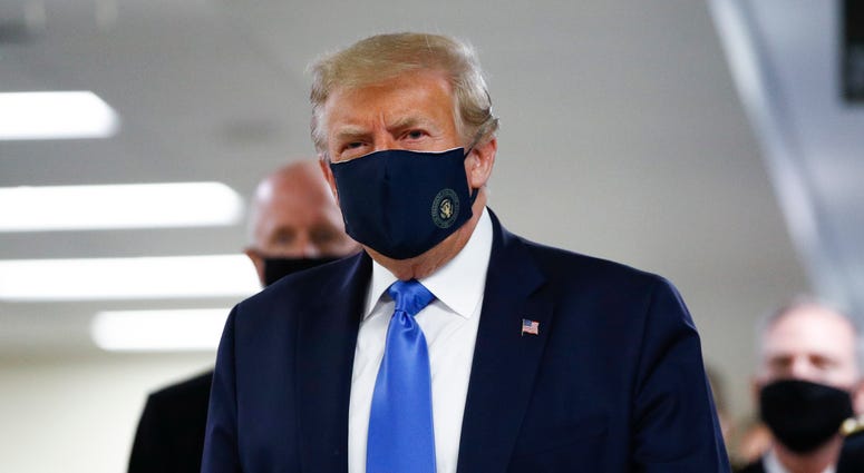 President Donald Trump wears a face mask as he walks down a hallway during a visit to Walter Reed National Military Medical Center in Bethesda, Md., Saturday, July 11, 2020. Trump mask
