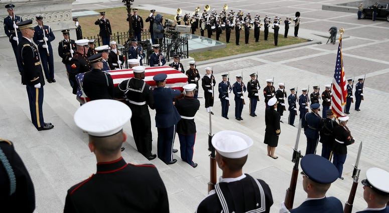 A U.S. military honor guard team carries the flag draped casket of former U.S. President George H. W. Bush from the U.S. Capitol December 5, 2018 in Washington, DC. George H.W. Bush