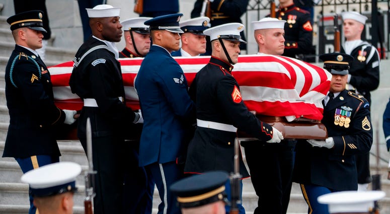 A U.S. military honor guard team carries the flag draped casket of former U.S. President George H. W. Bush from the U.S. Capitol December 5, 2018 in Washington, DC. George H.W. Bush
