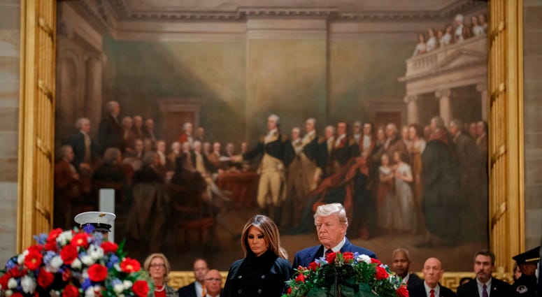 President Donald Trump and first lady Melania Trump pay their respects to former President George H.W. Bush as he lies in state in the U.S. Capitol Rotunda on December 3, 2018 in Washington, DC. George H.W. Bush