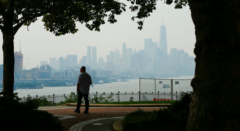 A man takes a look of the haze over the New York skyline and One World Trade Center on August 17, 2018 in Weehawken, New Jersey. Severe thunderstorms and even an isolated tornado could strike New York City on Friday. New York City skyline