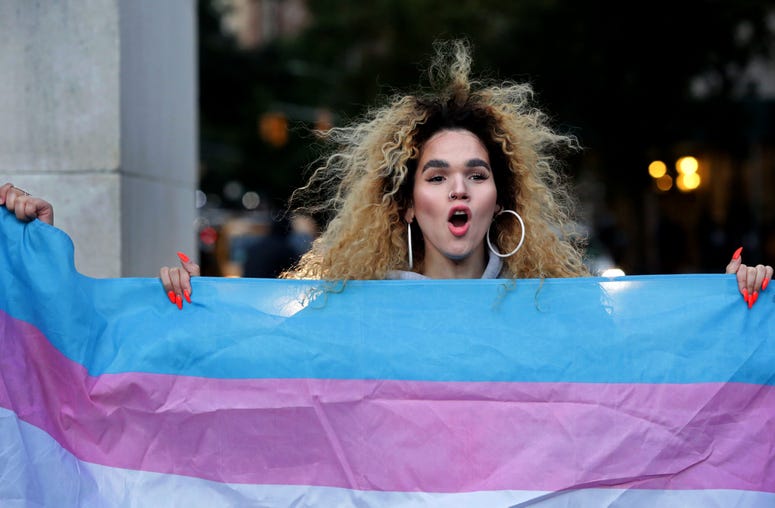 Morgin Dupont, 25, a woman of trans experience, holds up the flag for Transgender and Gender Noncomforming people at a rally for LGBTQI+ rights at Washington Square Park on October 21, 2018 in New York City. Yana Paskova/Getty Images