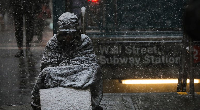 A homeless man sits in the falling snow in the Financial District, January 30, 2019 in New York City. A homeless man sits in the falling snow in the Financial District, January 30, 2019 in New York City.