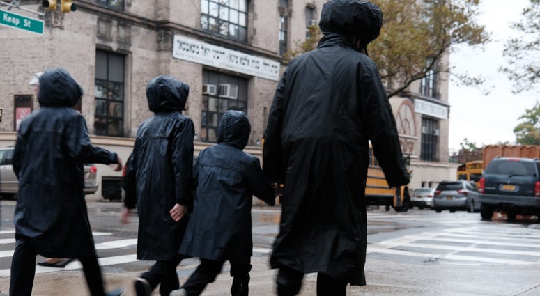 Members of the Jewish Orthodox community walk through a Brooklyn neighborhood on the Yom Kippur holiday on October 09, 2019 in New York City. Jewish Orthodox community