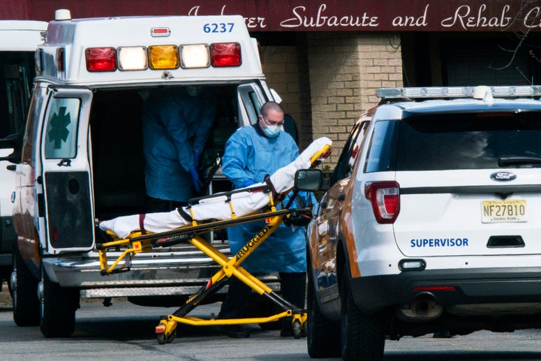 Medical workers prepare to transport a patient from Andover Subacute and Rehabilitation Center while wearing masks and personal protective equipment (PPE) on April 16, 2020 in Andover, New Jersey. Coronavirus New Jersey nursing home