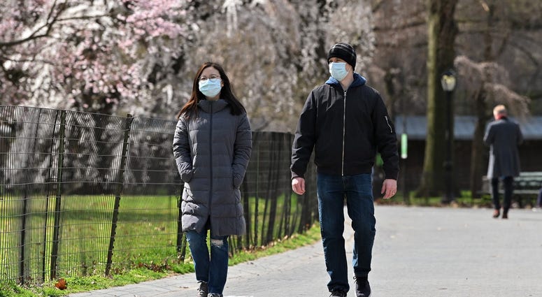 eople wearing protective masks are seen walking in Central Park as the coronavirus continues to spread across the United States on March 21, 2020 in New York City. Coronavirus NYC
